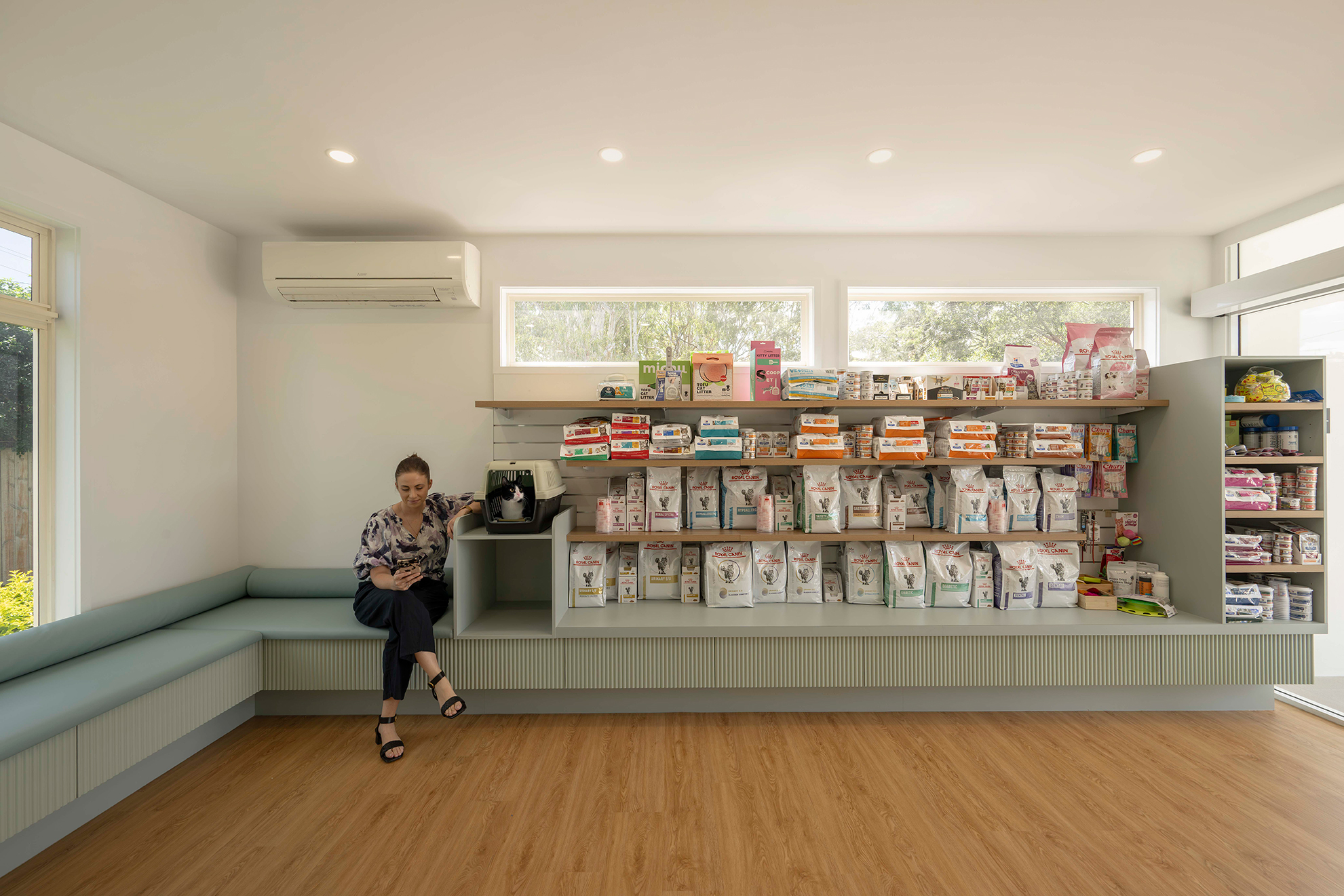Light grey and teal waiting room interior fitout for The Cat Clinic with retail product shelving